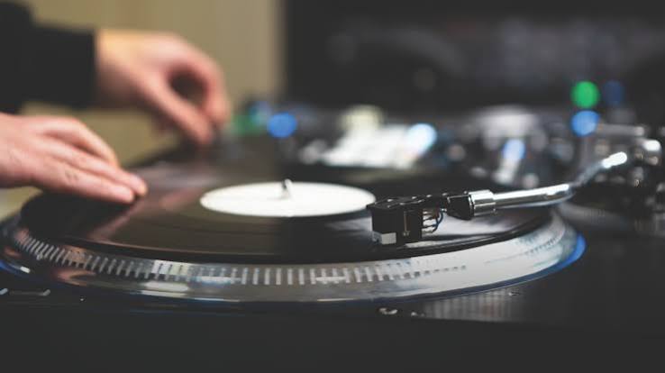Hands working a record on a turntable